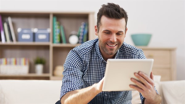 A man using a tablet and smiling
