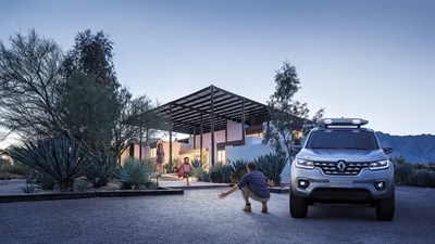 A child is running towards her dad who is sitting next to Renault ALASKAN concept car