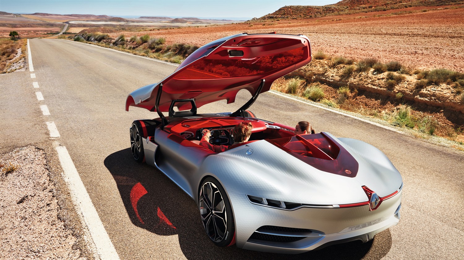 A couple sitting inside Renault TREZOR concept car with sliding roof door open