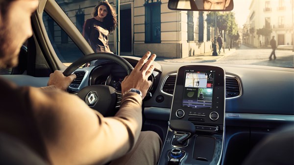 A driver driving his Renault car on the road using the navigation