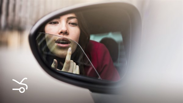 A woman looking in  Renault's car mirror
