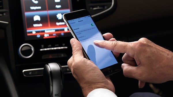 A person using bluetooth feature on his phone to connect the Renault multimedia system