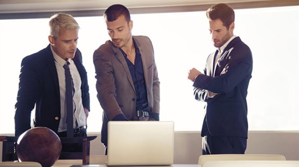 A discussion taking place between three well-dressed people